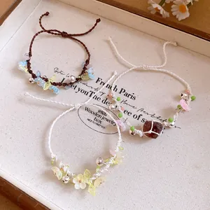 Vue détaillée de trois bracelets faits main avec fleurs en résine sur plateau lin