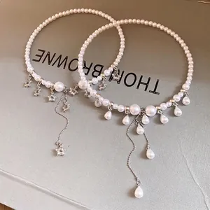 Elegant pearl choker necklace with intricate star charms and waterdrop tassel accents