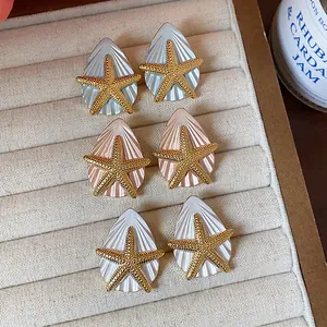 Detailansicht der hochwertigen Seestern- und Muschelohrringe in Gold- und Weiß-Finish