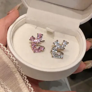 Dettaglio di orecchini ear cuff in zircone rosa e bianco in un portagioie elegante
