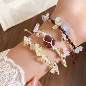 Détail macro de bracelets faits main avec fleurs en résine et petites cloches en métal