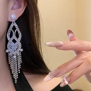 Detailed view of luxury silver rhinestone hollow tassel earrings worn on female ear