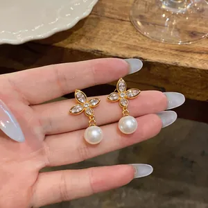 Detailed view of elegant butterfly pearl earrings with gold plating and zircons