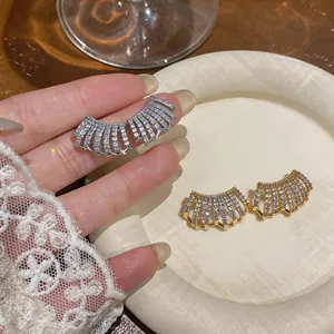 Primo piano di eleganti orecchini a lobo a C multistrato in oro 14K con zirconi