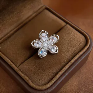 Close-up of an elegant zircon flower ear clip presented in a premium brown velvet box