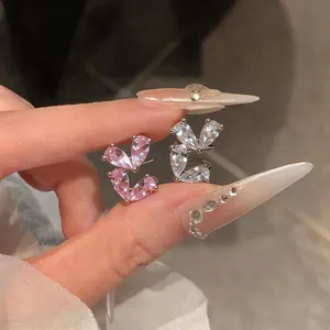 Dettaglio di orecchini a clip in zircone rosa e bianco a forma di cuore senza buco
