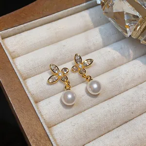 Detailed view of 18k gold plated butterfly stud earrings with zircons and pearls