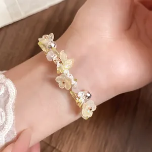 Bracelet de style coréen fait main avec fleurs en résine et clochettes sur le poignet