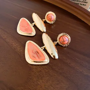 Detailed view of vintage orange geometric triangle earrings with hammered gold finish.