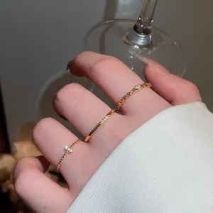 Dettaglio di tre anelli vintage placcati in oro con pietre di zircone scintillanti