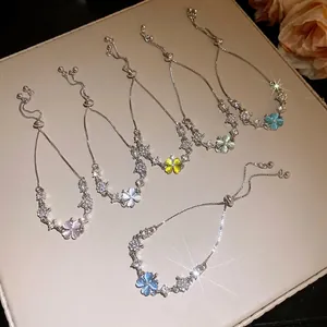 Detail view of adjustable silver bracelets with colorful cat-eye clover and zircon.