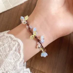 Gros plan d'un délicat bracelet à fleurs en résine et glands clochettes
