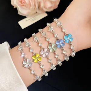 Close-up of colorful clover bracelets with cat eye stones and zircons on a model wrist