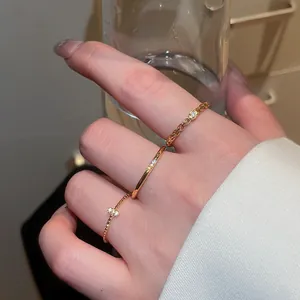 Primo piano di anelli in zircone color oro scintillanti su una mano, stile vintage.