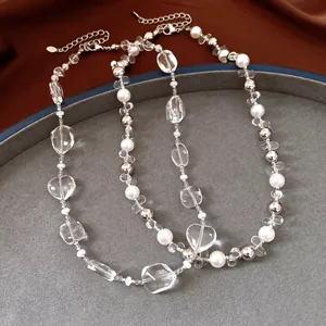 Detailed macro shot of a beaded necklace with pearls and clear crystal geometric beads.
