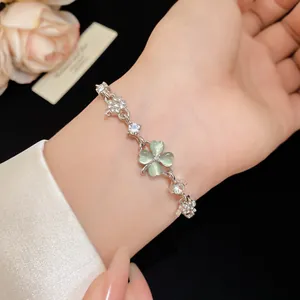 Detailed macro shot of a delicate silver bracelet featuring green cat-eye clover and zircons