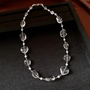 Detail view of transparent geometric crystal beads on a minimalist silver chain necklace