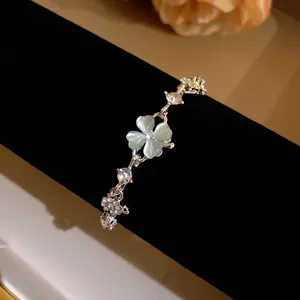 Detail view of silver clover bracelet featuring cat eye stone and sparkling zircons