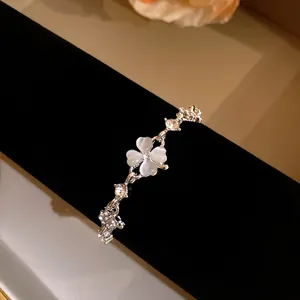 Close-up of elegant cat-eye stone four-leaf clover bracelet with sparkling zircons