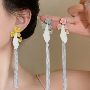 Detailed view of colorful enamel flower earrings with elegant silver long tassels.