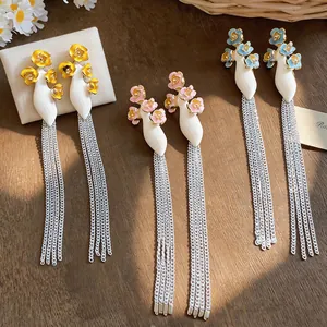 Detailed macro view of vibrant floral vase earrings with elegant long silver chain tassels