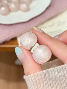 Close-up detail of sweet light pink round drip oil stud earrings with silver needles