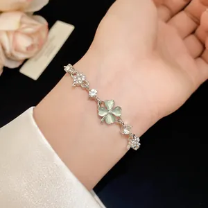 Detailed shot of cat's eye stone and zircon four-leaf clover bracelet on wrist