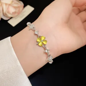 Detail view of a cat eye stone four leaf clover bracelet with sparkling zircon accents.