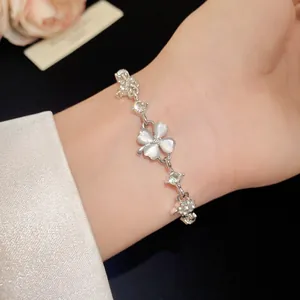 Detailed macro shot of the cat-eye stone four-leaf clover bracelet worn on the wrist