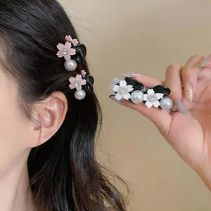 Detail of sweet floral hair claw clips with pearls and rhinestones on model's hair.