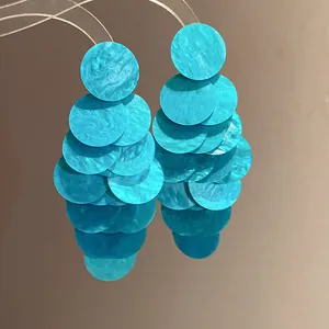 Detail of marbled turquoise acrylic round tiered earrings in resort style design