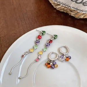 Close-up of colorful zircon tassel and hoop earrings with a vibrant dopamine-inspired design