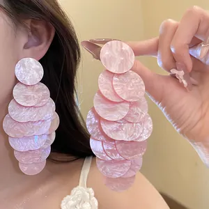 Macro detail of elegant pink marbled acrylic round layered tassel earrings for women
