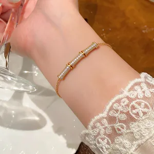 Detailed view of an 18k gold plated bamboo joint bracelet with sparkling zircons on a wrist.