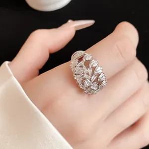 Detail view of a geometric hollow open ring with sparkling white cubic zirconia on a finger.