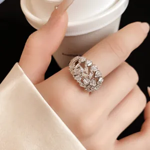 Macro shot of a silver geometric open ring set with sparkling zircons on an index finger