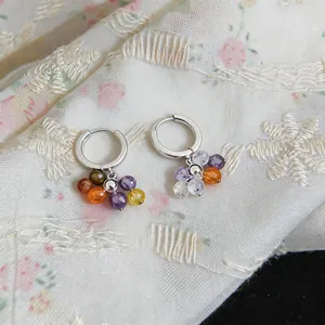Macro view of silver hoop earrings featuring vibrant and colorful zircon bead clusters
