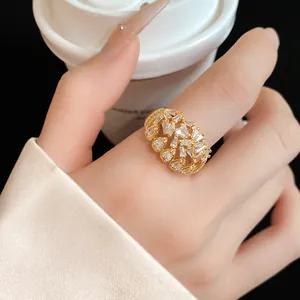 Macro view of a gold-plated geometric ring with zircon stones on a model's finger