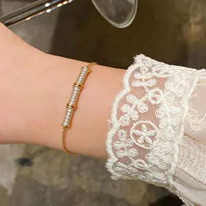 Detailed shot of an elegant 18k gold plated bamboo bracelet with pavé-set zircons on a wrist.
