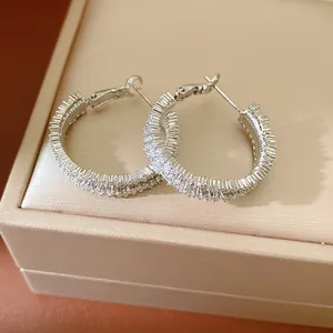 Close-up of silver-tone hoop earrings encrusted with sparkling cubic zirconia stones