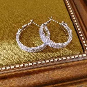 Detailed view of sparkling silver hoop earrings with densely set cubic zirconia stones.