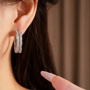 Detailed close-up showing shimmering silver hoop earrings set with small cubic zirconia stones