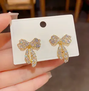 Vista dettagliata di eleganti orecchini a fiocco con scintillanti zirconi micro-pavé.