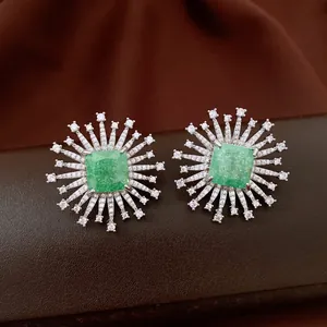 Dettaglio ravvicinato di orecchini a fiore in argento con pietra quadrata di zircone verde