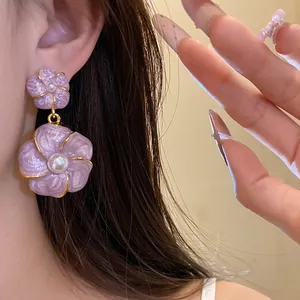 Elegant French vintage purple oil-drip flower drop earrings with pearls worn on ear