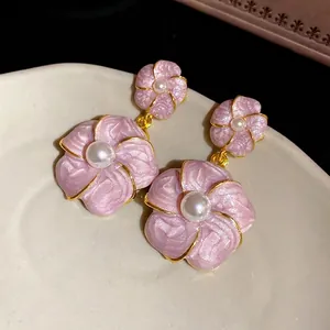 Elegant French vintage pink enamel flower stud earrings with central pearl accents.