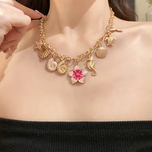 Vue détaillée d'un collier rétro doré avec fleur en émail et breloques de mer