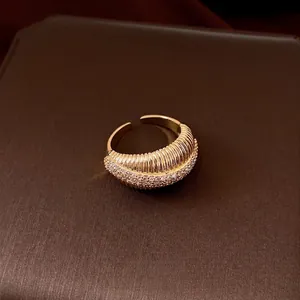 Elegante anello aperto placcato oro 14k con texture e pietre di zircone cubico.
