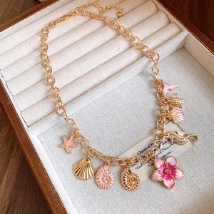 Gros plan détaillé d'un collier vintage émaillé avec des pendentifs coquillages et fleurs