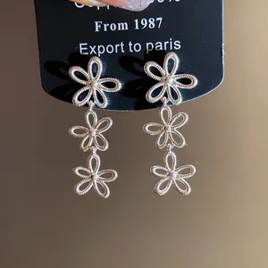 Detaillierte Nahaufnahme des filigranen dreifachen Blumen-Designs dieser silbernen Ohrhänger